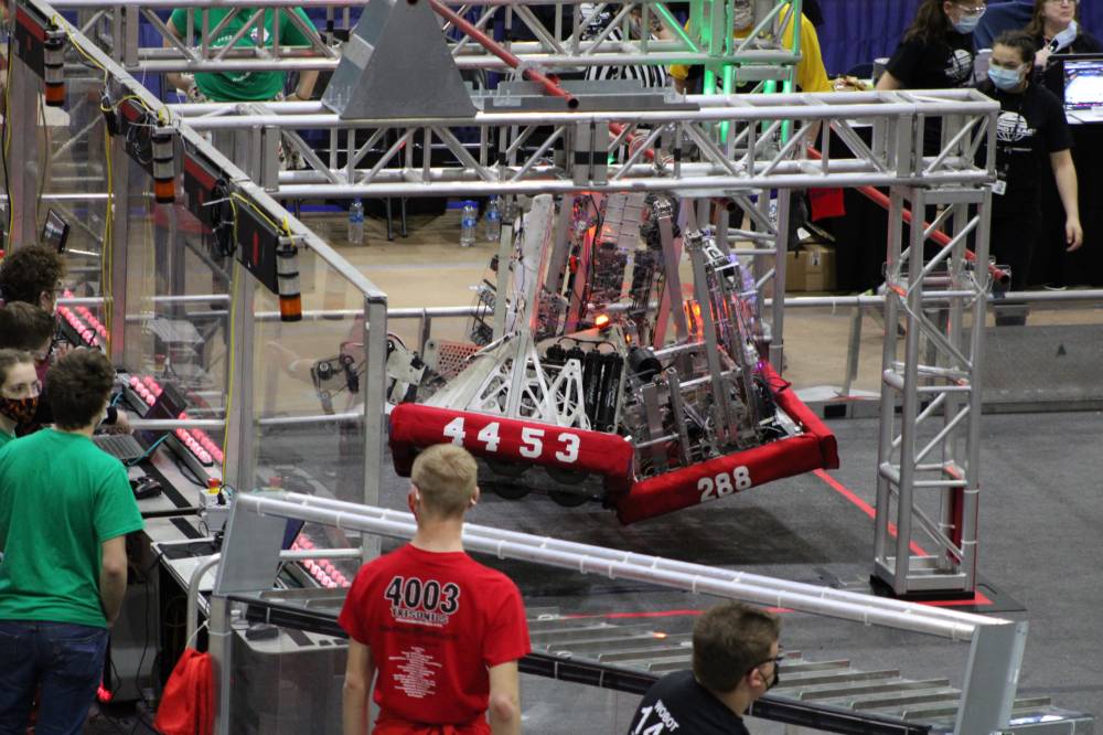Three robots hang together at the end of a match